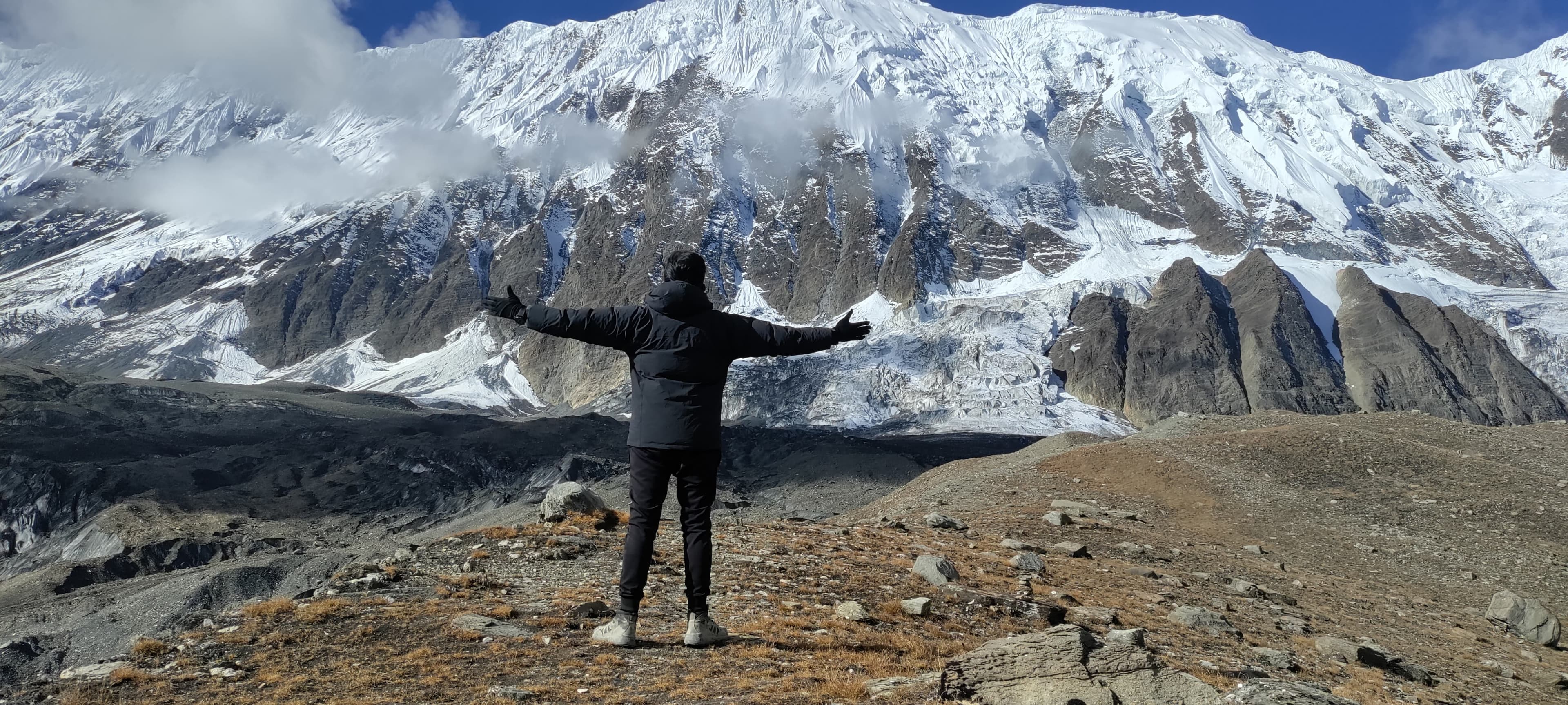 Man standing with snowy mountains behind